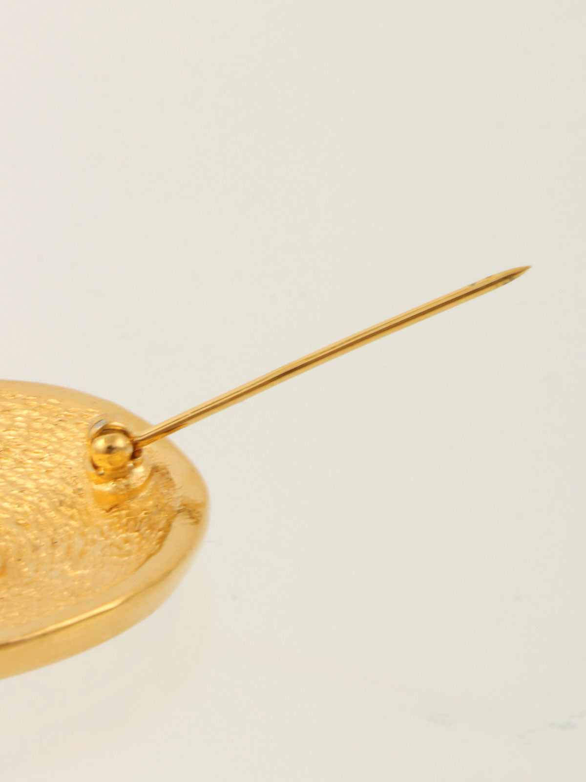 Round logo coin motif brooch in gold