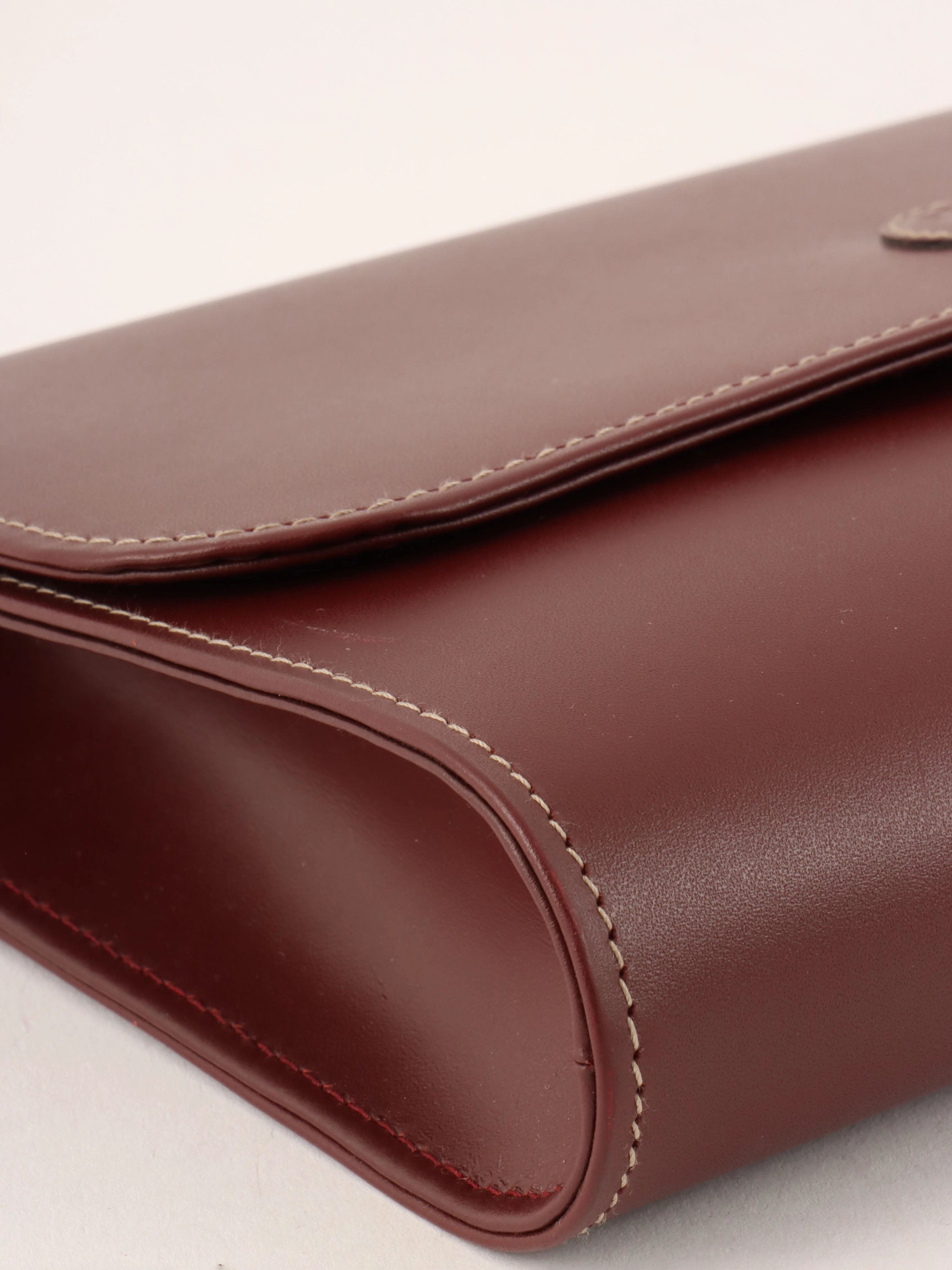 Logo embossed clutch bag in burgundy