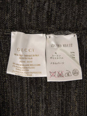 灰色V领针织衫，饰有品牌标志